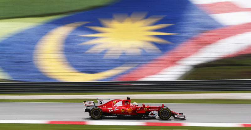 © Reuters. فيتل وزميله رايكونن يتفوقان في التجارب الحرة لسباق ماليزيا