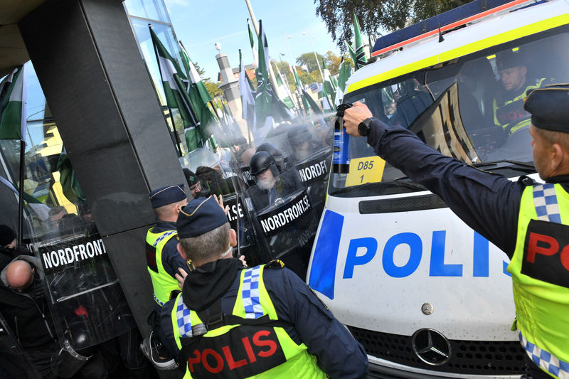 © Reuters. A police officer uses pepper spray on NMR demonstrators as they try to walk along a forbidden street during the Nordic Resistance Movement march in central Gothenburg