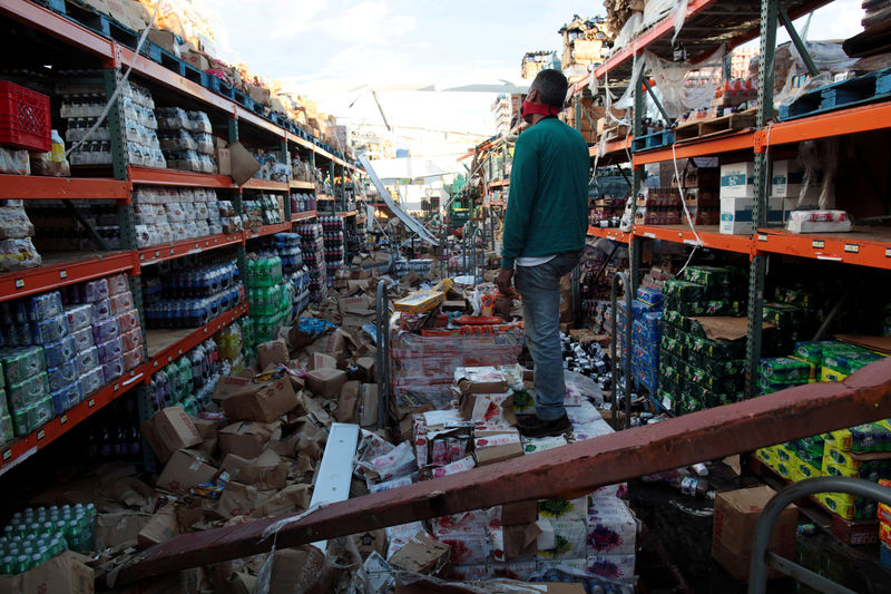 © Reuters. A man stands inside of a destroyed supermarket by Hurricane Maria in Salinas, Puerto Rico