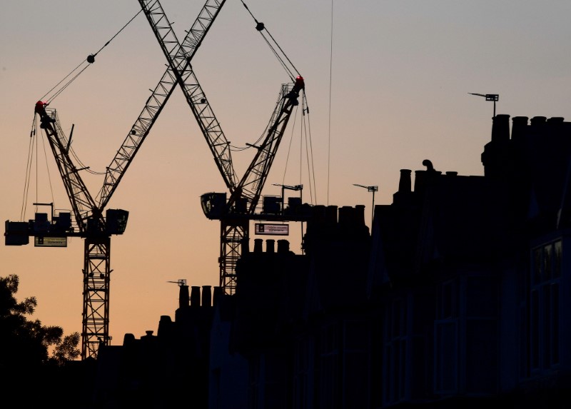 © Reuters. FILE PHOTO: Construction cranes are seen on a residential building project behind homes in London