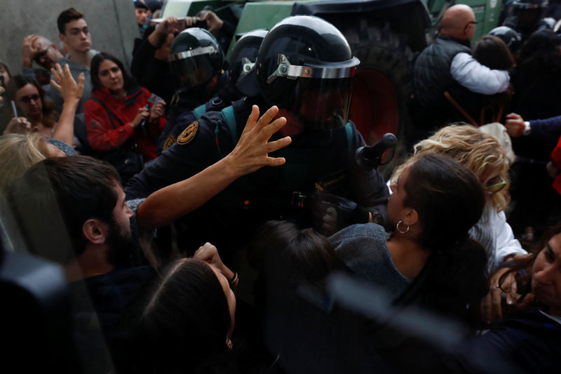 © Reuters. Scuffles break out as Spanish Civil Guard officers force their way through a crowd and into a polling station for the banned independence referendum in Sant Julia de Ramis