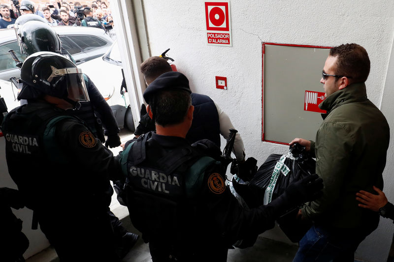 © Reuters. شرطة إسبانيا تقتحم مركز اقتراع سيدلي فيه زعيم إقليم قطالونيا بصوته