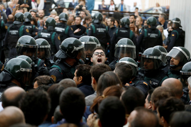 © Reuters. Scuffles break out as Spanish Civil Guard officers force their way through a crowd and into a polling station for the banned independence referendum in Sant Julia de Ramis