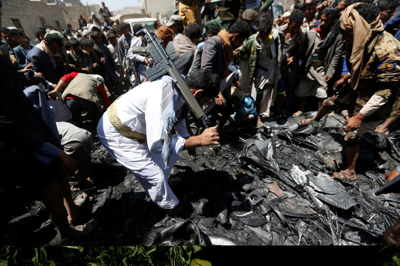 © Reuters. Houthi militants collect parts of a drone aircraft which the Houthi rebels said they have downed in Sanaa