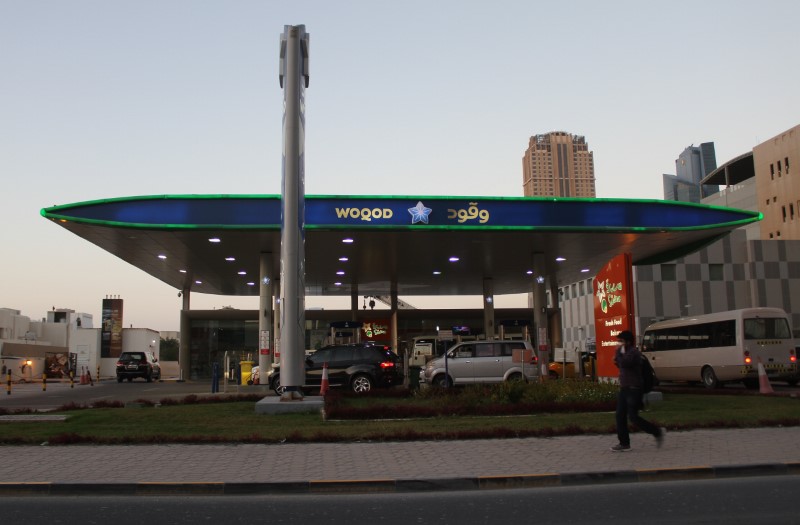 © Reuters. man walks past Woqod oil station in Doha