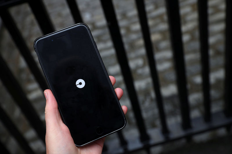 © Reuters. The Uber logo is seen on mobile telephone in London