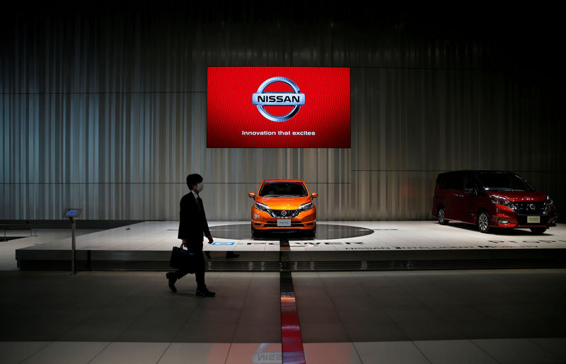 © Reuters. FILE PHOTO : A man walks in the Nissan showroom at the carmaker's headquarters in Yokohama