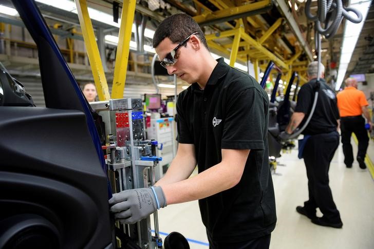 © Reuters. FILE PHOTO - Workers assemble cars at the plant for the Mini range of cars in Cowley, near Oxford