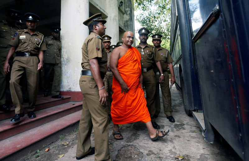 © Reuters. Sri Lanka's Buddhist monk Dayarathana, who led hardline nationalists in an unruly protest against 31 Rohingya Muslim asylum seekers last week, is escorted to prison bus by prison and police officers in Mount Lavinia