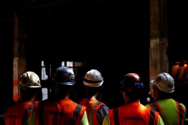 © Reuters. Construction workers attend an announcement by New York Governor Andrew Cuomo at The Moynihan Train Hall in New York