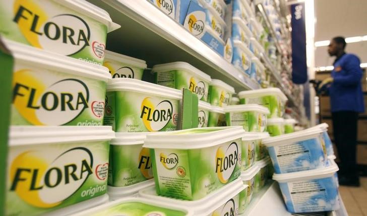 © Reuters. A worker scans barcodes by a chiller cabinet of Flora margarine at a Sainsbury's supermarket in London