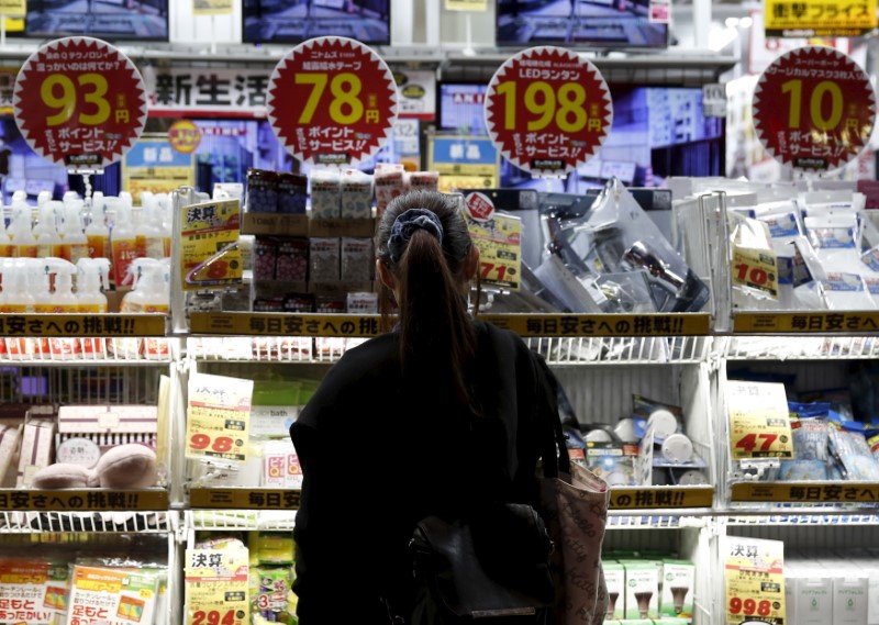 © Reuters. A woman looks at items outside an outlet store at a shopping district in Tokyo