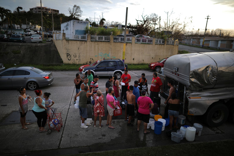 © Reuters. Local residents wait in line during a water distribution in Bayamon following damages caused by Hurricane Maria in Carolina, Puerto Rico