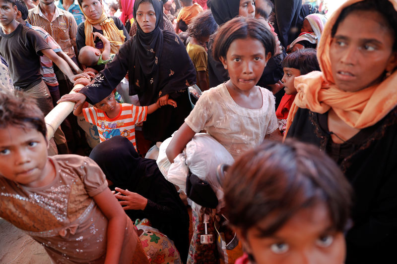 © Reuters. Rohingya refugees who just arrived by wooden boats from Myanmar wait for some aid to be distributed at a relief centre in Teknaf