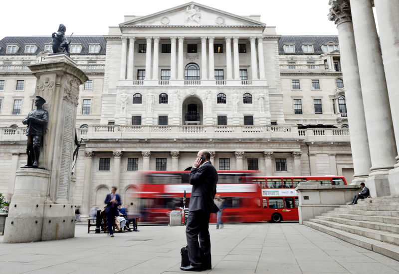 © Reuters. A man talks on a mobile phone as people walk past the Bank of England, in London