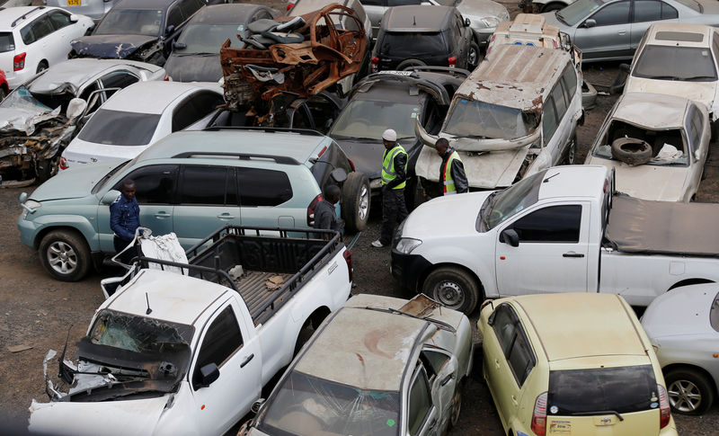© Reuters. Dealers inspect vehicles before their auction at the Leakey's auctioneers yard in Nairobi