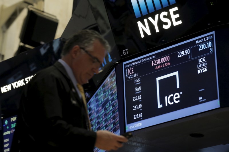 © Reuters. A trader passes by a screen that displays the trading info for Intercontinental Exchange Inc. (ICE) on the floor of the NYSE