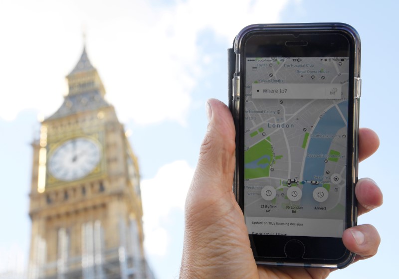 © Reuters. FILE PHOTO: A photo illustration shows the Uber app on a mobile telephone, as it is held up for a posed photograph in central London
