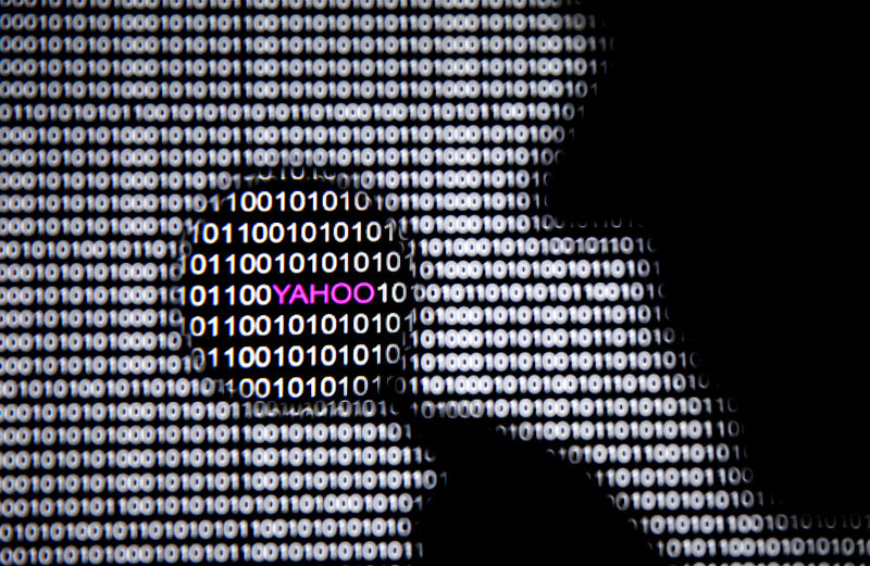 © Reuters. FILE PHOTO: A photo illustration shows a man in front of a Yahoo logo seen through a magnifying glass in front of a displayed cyber code