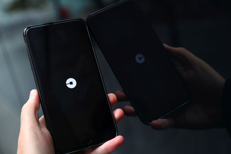 © Reuters. The Uber logo is seen on mobile telephone in London