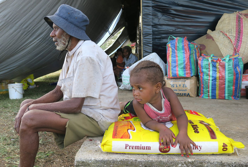 © Reuters. Residents evacuated due to the Manaro Voui volcano, located on Vanuatu's northern island Ambae, sit near their possessions and food supplies at an evacuation center in Luganville, on Vanuatu's Espiritu Santos Island located in the South Pacific