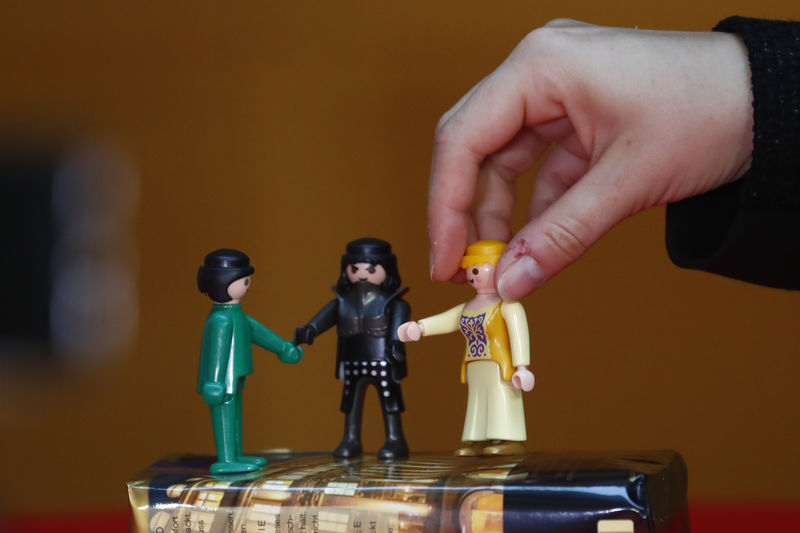 © Reuters. Journalists set up toy figures for a possible so-called Jamaica coalition of Christian Democratic Union CDU party, the Alliance 90/The Greens party and Free Democrats (FDP) before a press conference in Berlin