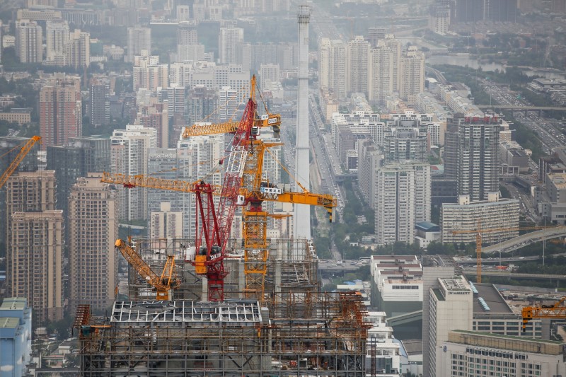 © Reuters. Cranes are seen on top of a skyscraper that is under construction in Beijing