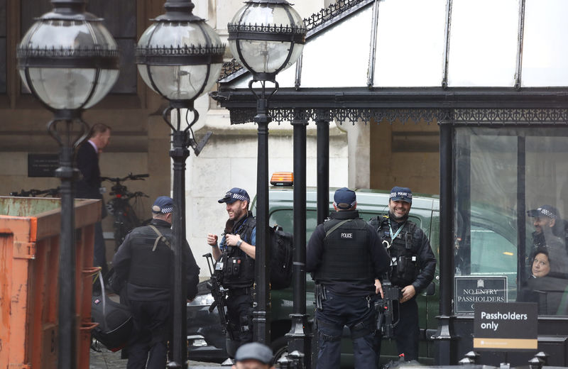 © Reuters. Armed police gather outside an entrance to the Houses of Parliament in London