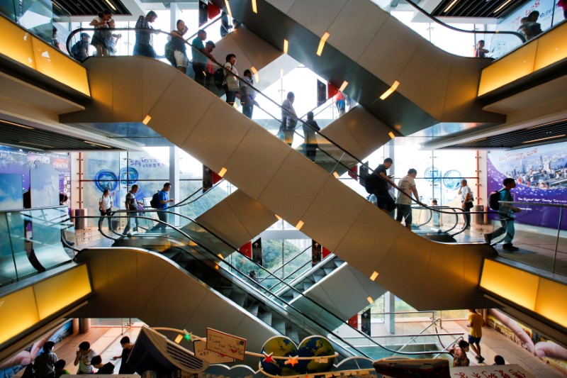 © Reuters. FILE PHOTO: Tourists descend on an escalator inside a shopping mall at the Peak in Hong Kong