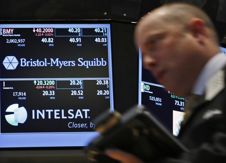 © Reuters. A trader passes by a screen displaying the tickers symbols for Bristol-Myers Squibb on the floor at the New York Stock Exchange