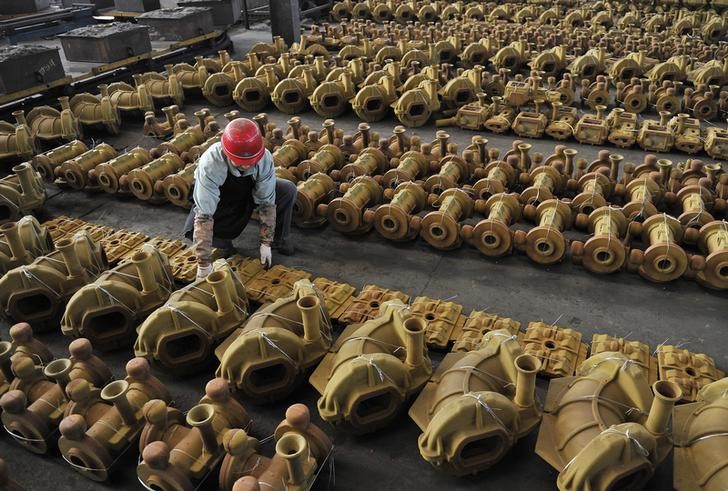 © Reuters. A worker moves a pipe fitting inside a factory in Hefei