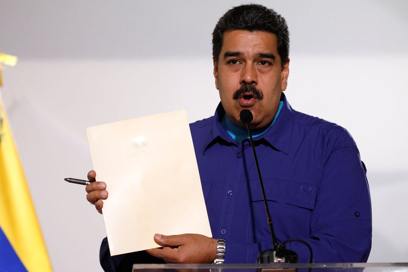 © Reuters. FILE PHOTO - Venezuela's President Nicolas Maduro holds a document as he talks to the media before an event with supporters of Somos Venezuela (We are Venezuela) movement in Caracas
