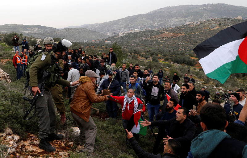 © Reuters. سكان بلدة فلسطينية يحاولون منع المستوطنين من إقامة مستوطنة على أراضيهم