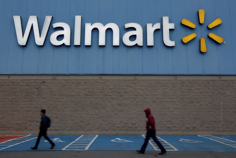 © Reuters. FILE PHOTO: Men walk past the logo of Walmart outside a store in Monterrey