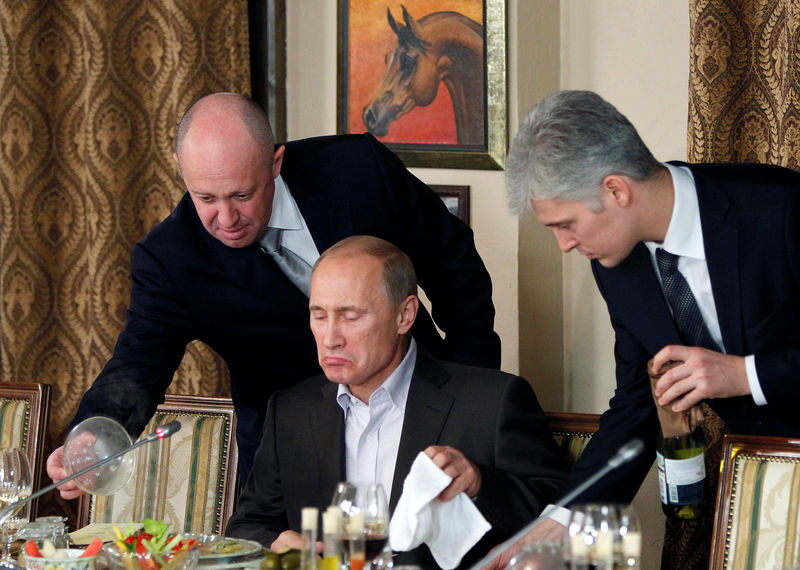 © Reuters. FILE PHOTO:    Evgeny Prigozhin assists Russian Prime Minister Vladimir Putin during a dinner with foreign scholars and journalists at the restaurant Cheval Blanc on the premises of an equestrian complex outside Moscow