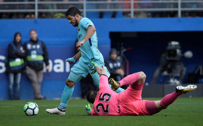 © Reuters. El delantero uruguayo Luis Suárez del Barcelona supera al portero Marko Dmitrovic del Éibar antes de anotar su primer gol