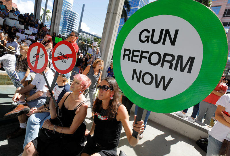 © Reuters. Protesters hold signs as they call for a reform of gun laws three days after the shooting at Marjory Stoneman Douglas High School, at a rally in Fort Lauderdale