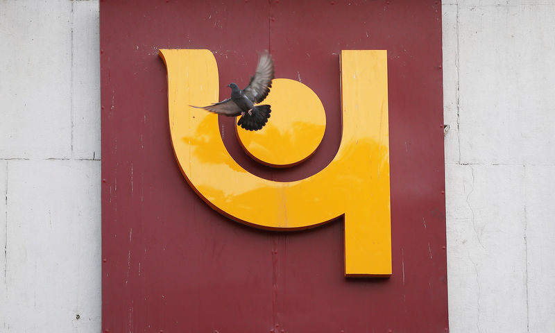 © Reuters. A pigeon flies past the logo of Punjab National Bank outside a branch of the bank in New Delhi