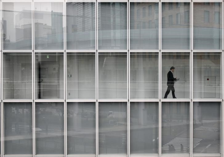© Reuters. A man walks inside an office building in Tokyo