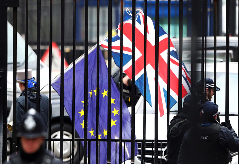 © Reuters. FILE PHOTO: A demonstrator carries a Union Jack and a European Union flag as the EU's chief Brexit negotiator Michel Barnier visits Downing Street in London