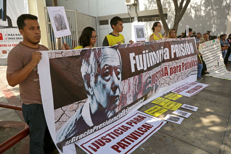 © Reuters. Manifestantes y familiares de víctimas del caso Pativilca protestan fuera de un tribunal que juzga al expresidente peruano Alberto Fujimori