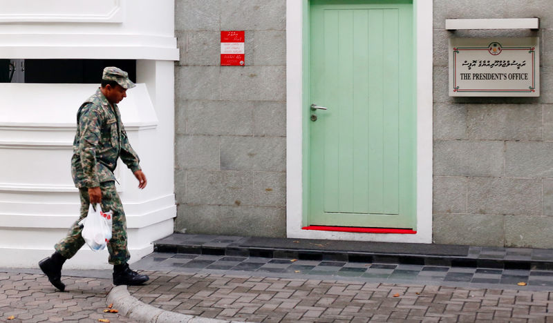 © Reuters. A Maldives National Defence Force soldier walks past the president's office building after Maldives President Abdulla Yameen declared a state of emergency, in Male