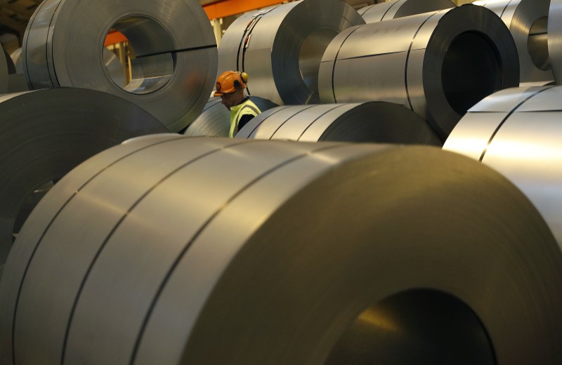 © Reuters. FILE PHOTO - A worker walks through coils of steel to be used on Tata Steel's new robotic welding line at their Automotive Service Centre in Wednesfield