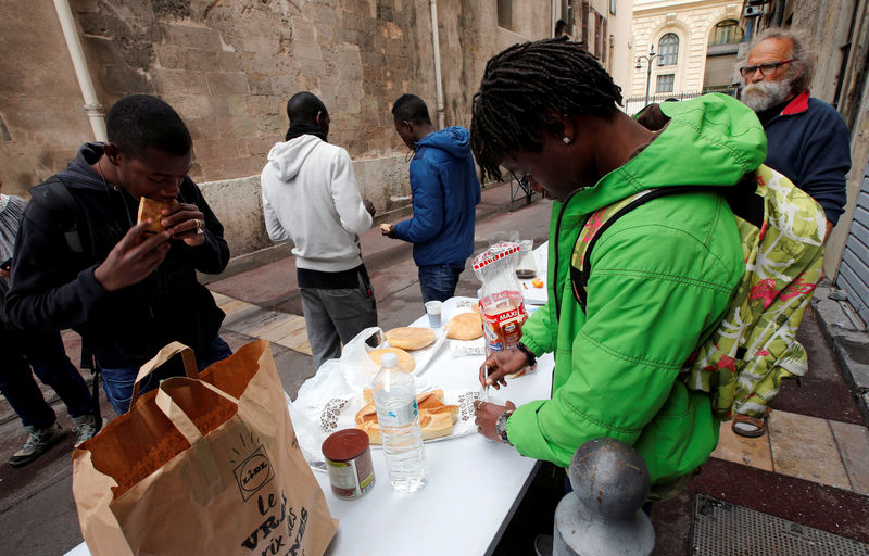 © Reuters. FILE PHOTO: Volunteers distribute foods to migrants as they occupy the Saint Ferreol church to protest against the life conditions of unaccompanied minor migrants in Marseille