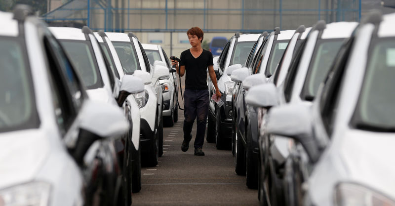 © Reuters. FILE PHOTO: A worker checks cars made by GM Korea in a yard of GM Korea's Bupyeong plant in Incheon