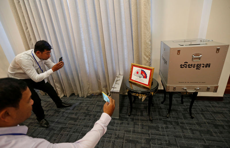 © Reuters. Journalists take photos of a ballot box donated by the Government of Japan at the Ministry of Foreign Affairs and International Cooperation in Phnom Penh