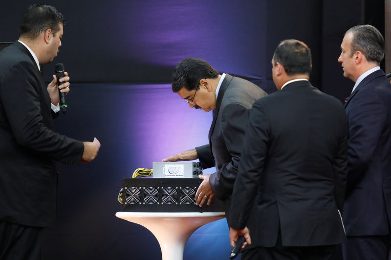 © Reuters. Venezuela's President Nicolas Maduro examines a cryptocurrency mining computer during the event launching the new Venezuelan cryptocurrency "Petro" in Caracas
