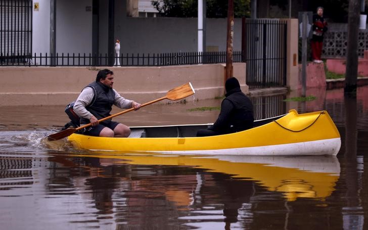 © Reuters. Una persona en canoa por una calle inundada en Lujan, Argentina