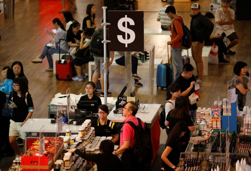 © Reuters. FILE PHOTO - People shop at a pop-up store in Singapore