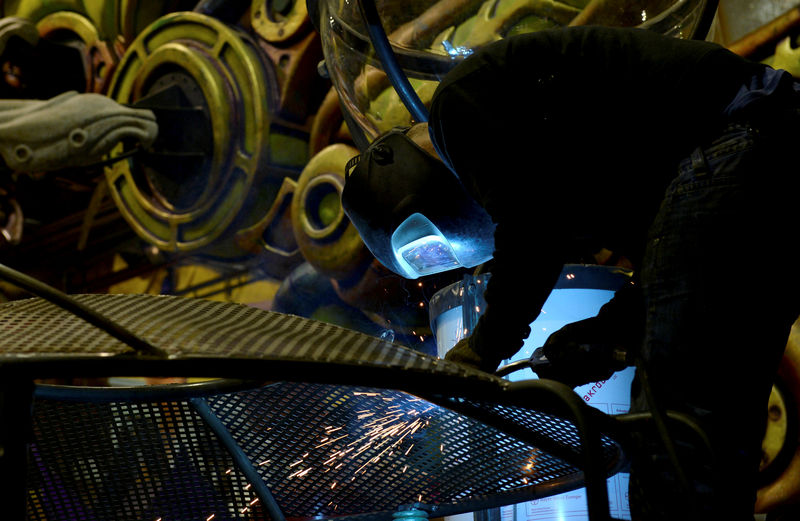 © Reuters. FILE PHOTO: A welder works on the structure of a float as preparations continue for the Carnival parade in Nice
